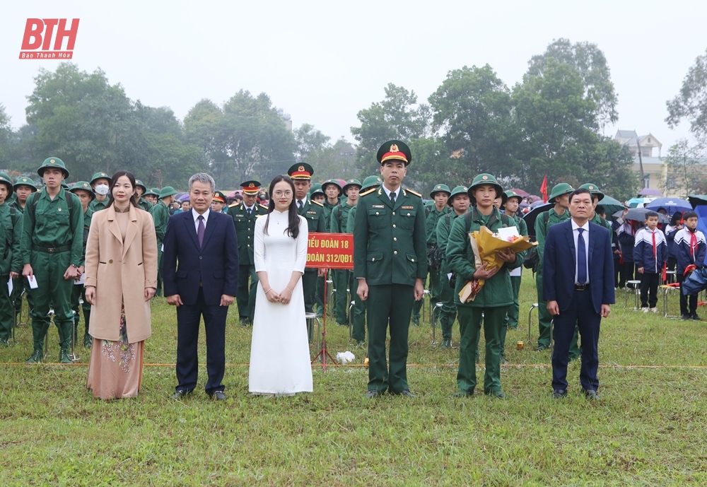 Đồng chí Trịnh Xuân Phú, Tỉnh ủy viên, Bí thư Thị ủy, Chủ tịch HĐND thị xã; đồng chí Nguyễn Quốc Đạt, Phó Chủ tịch HĐND thị xã; đồng chí Lê Thị Kim Hằng, Trưởng ban Tuyên giáo Thị ủy tặng hoa, động viên chiến sỹ yên tâm lên đường nhập ngũ (Ảnh Báo Thanh Hóa)