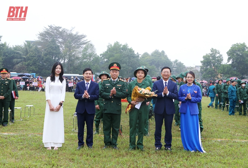 Đồng chí Nguyễn Thế Anh, Chủ tịch UBND thị xã, Chủ tịch Hội đồng Nghĩa vụ quân sự thị xã; đồng chí Lê Văn Thông, Chủ nhiệm Ủy ban Kiểm tra Thị ủy và đồng chí Trần Thị Ngọc Ánh, Bí thư Thị Đoàn tặng hoa động viên chiến sỹ mới yên tâm lên đường nhập ngũ (Ảnh Báo Thanh Hóa)