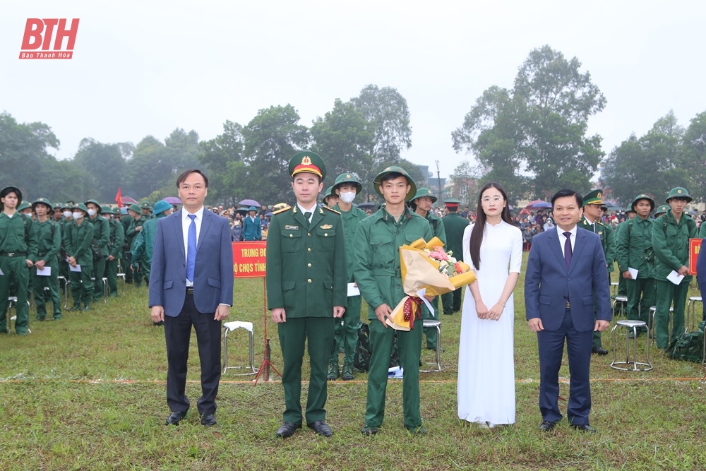 Đồng chí Trương Bá Duyên, Phó Bí thư Thường trực Thị ủy và đồng chí Trịnh Tiến Dũng, Phó Chủ tịch UBND thị xã tặng hoa, động viên chiến sỹ mới yên tâm lên đường nhập ngũ (Ảnh Báo Thanh Hóa)