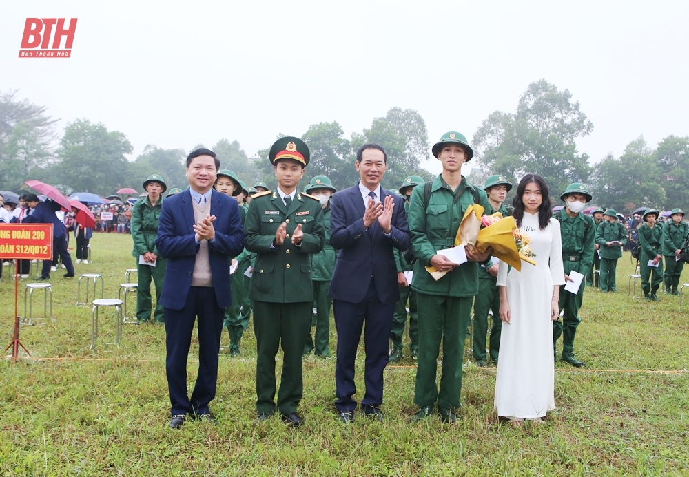 Đồng chí Trịnh Tuấn Sinh, Phó Bí thư Tỉnh ủy và đồng chí Mai Sỹ Lân, Phó Chủ tịch UBND thị xã tặng hoa động viên chiến sĩ mới yên tâm lên đường nhập ngũ (ảnh Báo Thanh Hóa).