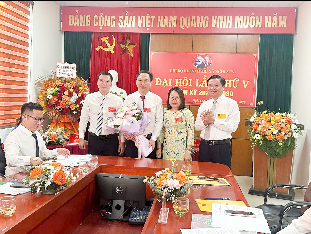 Đồng chí Mai Sỹ Lân, Phó Chủ tịch UBND thị xã tặng hoa chúc mừng chi ủy chi bộ