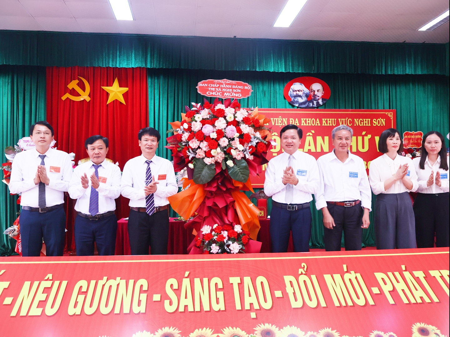 Đồng chí Mai Sỹ Lân, Phó Chủ tịch UBND thị xã tặng hoa chúc mừng Đảng bộ bệnh viện